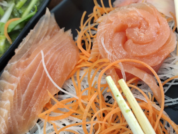 生鲜三文鱼片或日式三文鱼生鱼片加冰，在室内昏暗的光线下配上新鲜的芥末照片。在一家餐馆图片下载