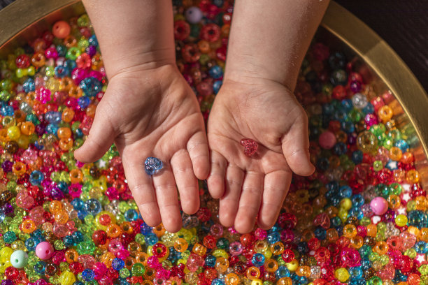 女孩的手拿着彩色心形珠子图片下载