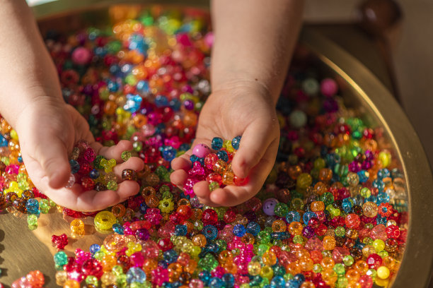 女孩的手拿着彩色心形珠子图片下载