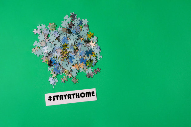 谜题和带标签的纸留在家里绿色的纸背景，有拷贝空间图片下载