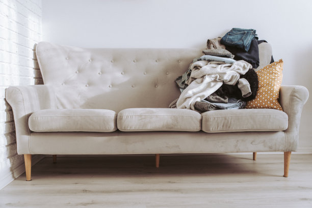 沙发上一堆未摊开的衣服待洗。一堆用来捐赠或回收的旧衣服图片下载