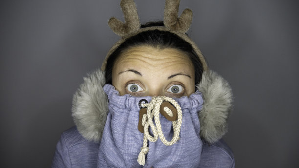 一名身穿运动衫、戴着驯鹿耳套的妇女直视着镜头。图片下载