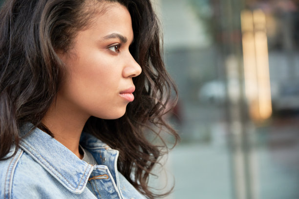 自信的年轻非洲裔美国妇女在城市街道上向前看。图片下载