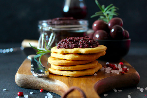 罐子里的橄榄酱，饼干和橄榄，配红酒，深色背景。图片下载