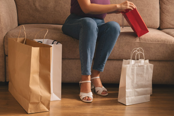 拿着购物袋坐在沙发上的女人图片下载
