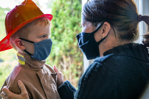 2019冠状病毒病大流行前夕，母亲给孩子戴上防护口罩图片下载