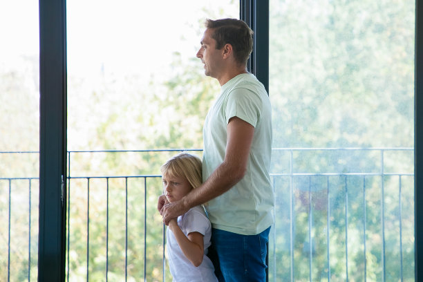 快乐的爸爸拥抱女儿，看着全景窗口图片下载