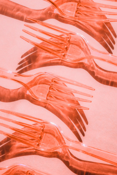 粉红色背景上的塑料透明叉子的阴影抽象构图图片下载