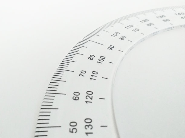 近距离的量角器测量度孤立在白色背景。测量和构造角度的数学仪器。倾角计。测量工具。圆测量尺度。图片下载