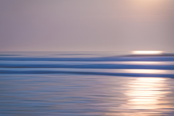 抽象海景与模糊平移运动。日出或日落在海上，美丽的浅蓝色和粉红色图片下载