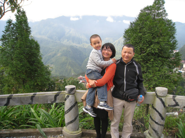 一个幸福的家庭和一个孩子站在山顶的冬天图片下载