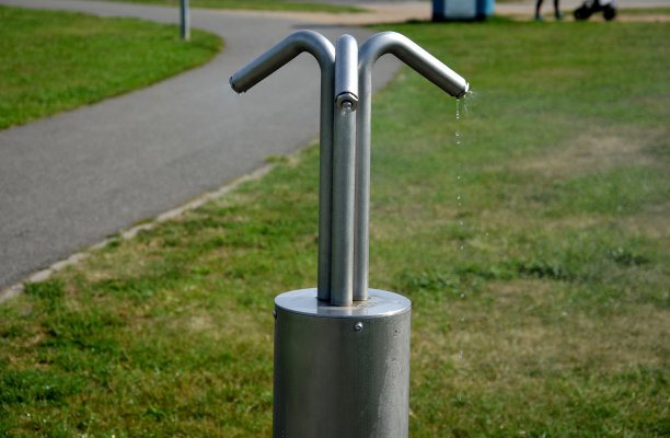 炎炎夏日，在公园里使用不锈钢微滴喷雾器的公园空气清新剂，可以缓解跑步者的疲劳。孩子们在这里玩得很开心图片下载