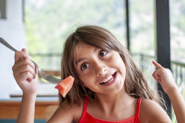 可爱的女孩吃和享受西瓜图片下载