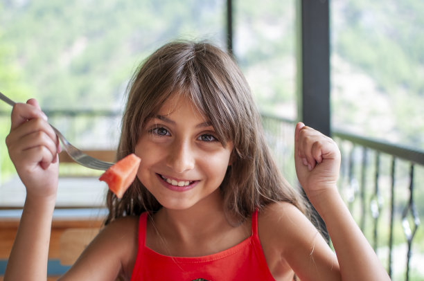 可爱的女孩吃和享受西瓜图片下载