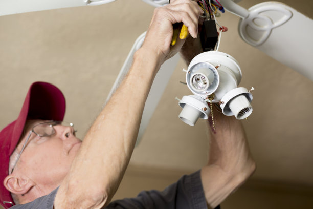 蓝领工人。电工修理吊扇。图片下载