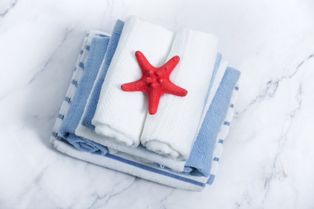 蓝色和白色的毛巾堆叠在桌面上。图片下载