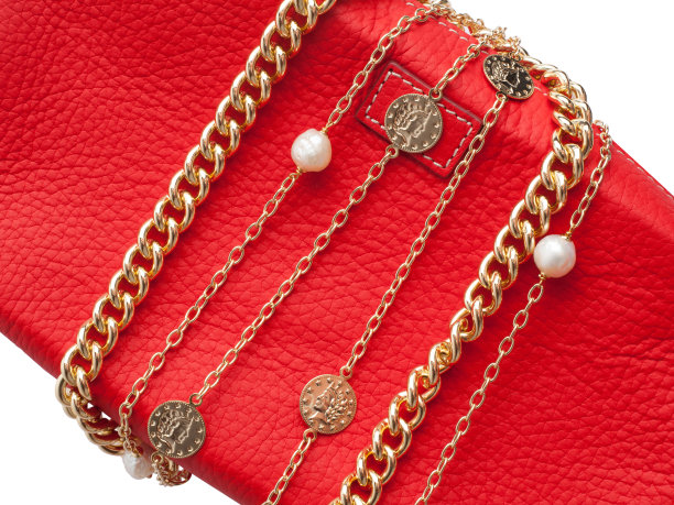 两个女人的金项链上的女性红色皮革化妆包图片下载