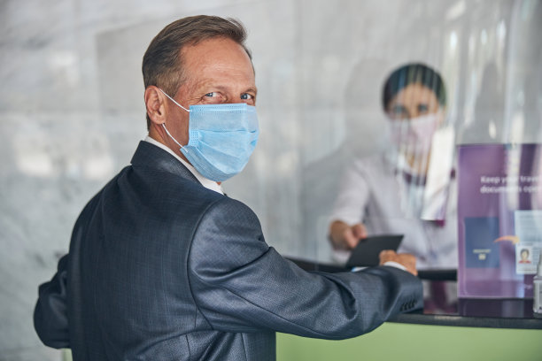 疫情期间，兴高采烈的商人在机场办理登机手续图片下载