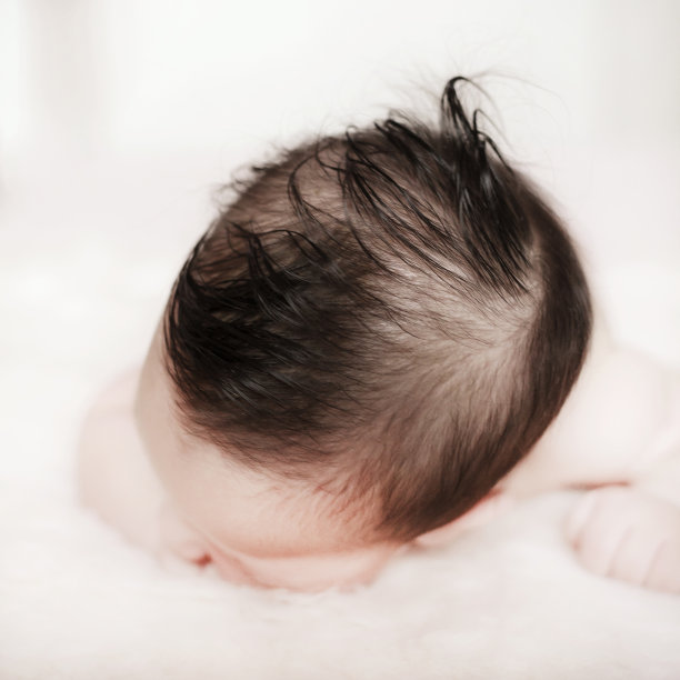 俯卧的婴儿和他的卷发图片下载