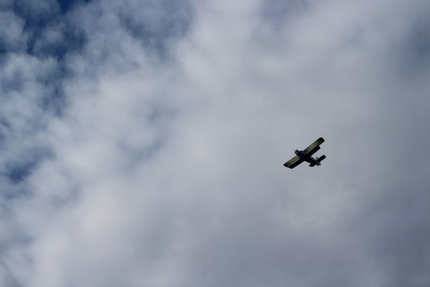 飞机在阴沉多云的天空中飞行的照片图片下载