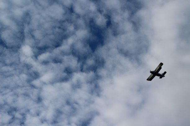 飞机在阴沉多云的天空中飞行的照片图片下载