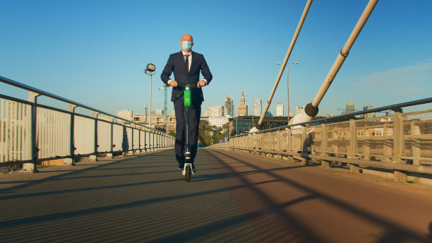 商人戴着面具骑摩托车。过桥。市内交通安全图片下载