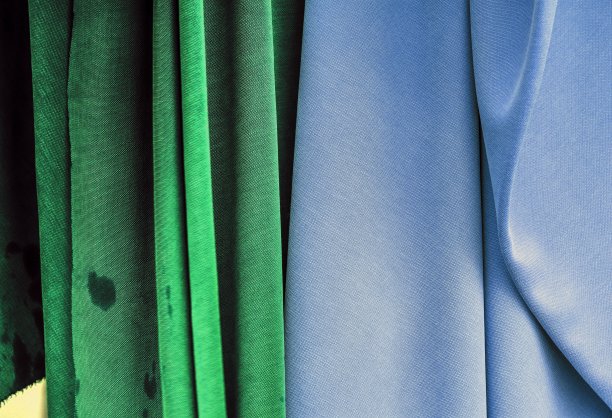 在面料市场上发现的不同颜色的布料和织物样品的详细近距离查看图片下载