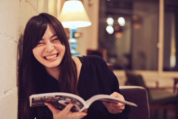 一个留着长发的女人在咖啡厅里看杂志图片下载