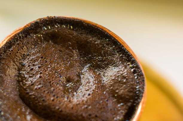 天然咖啡与厚泡沫，煮铜cezve在古典方式，在木制背景，微距照片。图片下载