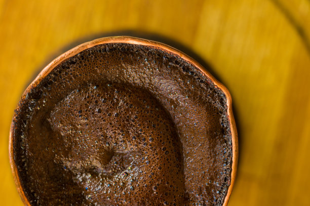 天然咖啡与厚泡沫，煮铜cezve在古典方式，在木制背景，微距照片。图片下载