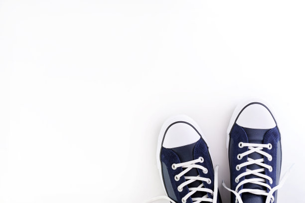 蓝色背景上的蓝色皮革运动鞋。一双时髦的蓝色运动鞋或运动鞋与文本或设计的拷贝空间。这是新款蓝色运动鞋的上照。俯视图或平铺。图片下载