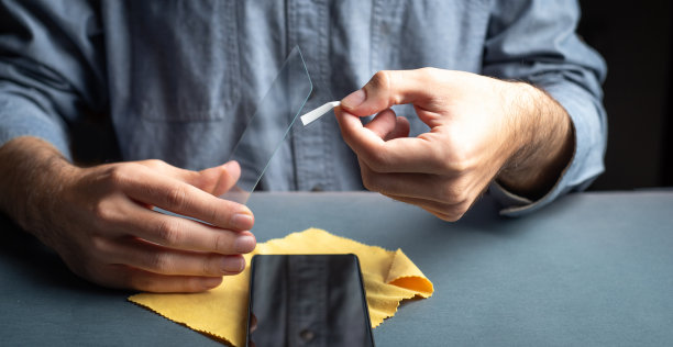 男子将防刮保护玻璃应用到智能手机屏幕近距离图片下载