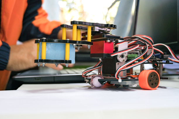 机器人技术，STEM教育实验室学习编码学习概念:金属机器人和电子板机器人与学生在计算机实验室科学教室学习编程图片下载