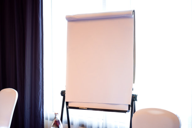 纸张:在白纸背景上画有腿的真实空白挂图，或在公司培训简报会上或大学课堂上卷起来作展示图片下载