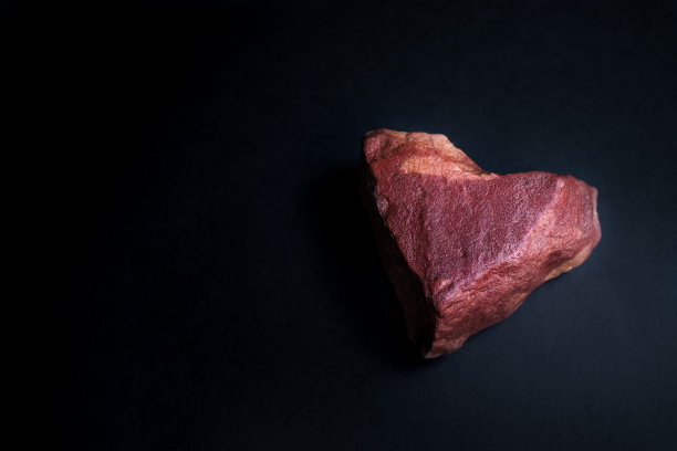 黑暗肮脏的红色心形石头在黑色的背景图片下载