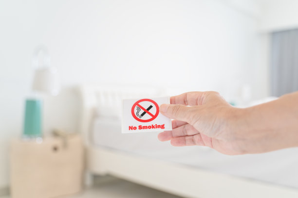 人类的手握着禁止吸烟标志与模糊的卧室，在软焦点图片下载