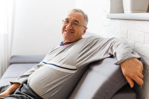 一位老人坐在他家里的椅子上，特写与复印空间图片下载