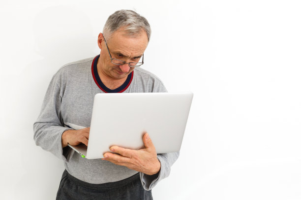 微笑快乐的老人与笔记本电脑。在白色背景上隔离图片下载