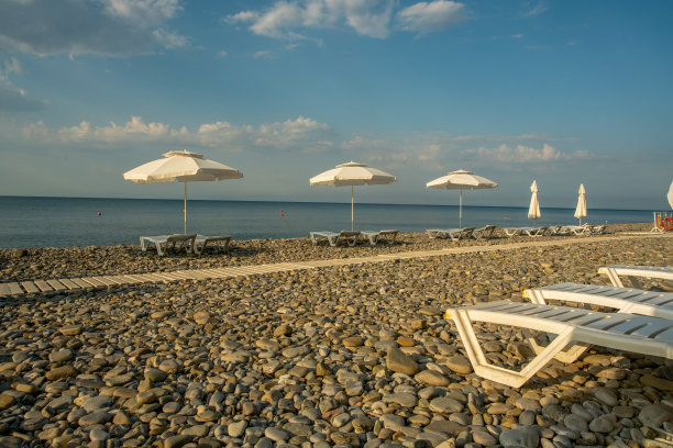 海滩上田园诗般的早晨:日光浴躺椅和雨伞图片下载