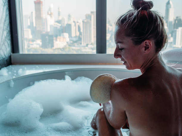 一位年轻女子正在沐浴，还能看到城市风景图片下载