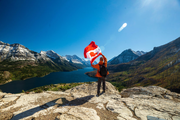 沃特顿湖国家公园和手持加拿大国旗的男子图片下载