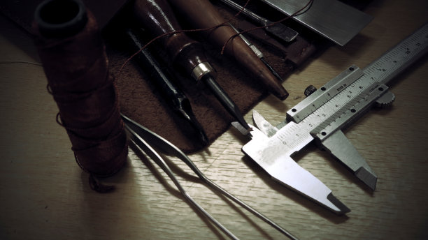 传统作坊的木桌上放置着皮革工艺工具图片下载