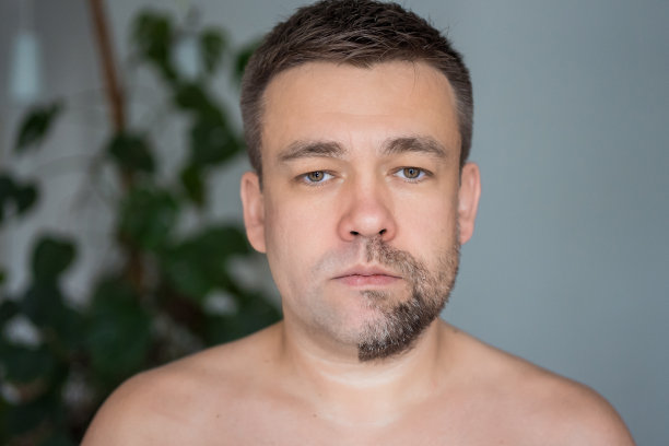 一个悲伤的男人，一边留胡茬，另一边刮毛图片下载