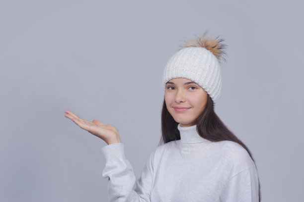 戴着帽子的女孩空着手看相机图片下载