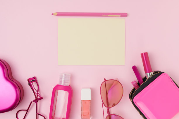 用化妆品和笔记本纸平躺在粉红色上图片下载