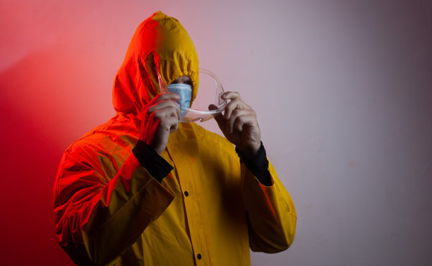 一位身着黄色套装、带着兜帽的研究人员戴着安全眼镜，图片下载