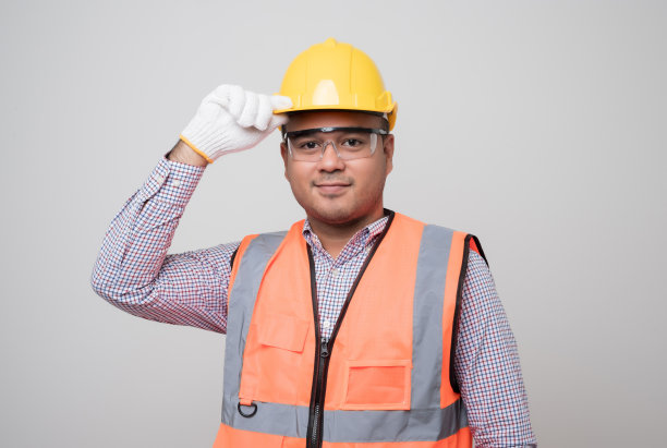 微笑年轻的亚洲土木工程师戴着头盔安全帽站在孤立的白色背景。技工服务理念。图片下载