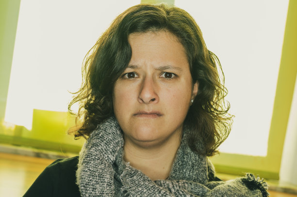 一名年轻女子在镜头前看上去满腹狐疑、缺乏安全感，还有点害怕。图片下载