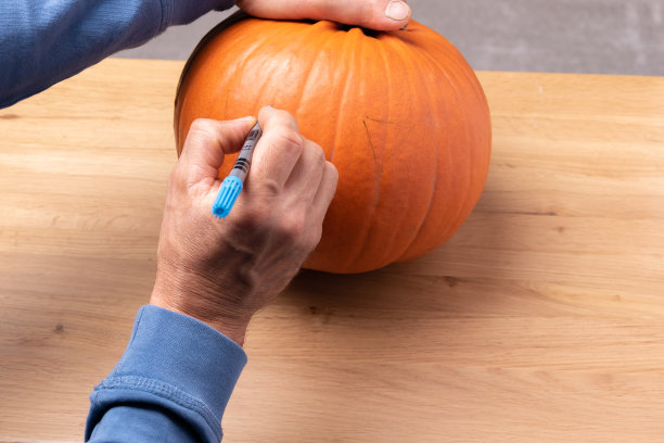 在南瓜上画南瓜灯。微笑万圣节南瓜节日装饰。图片下载