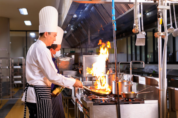 亚洲男厨师和他的同事在酒店厨房做饭图片下载